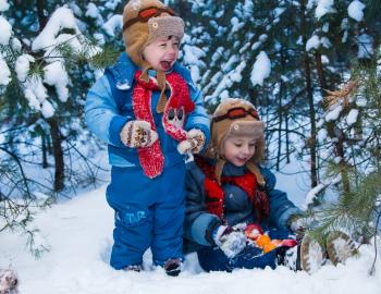 Two infants playing in snow